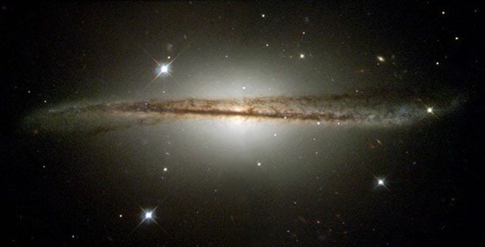 An unusual edge-on galaxy with a warped, dusty disc.